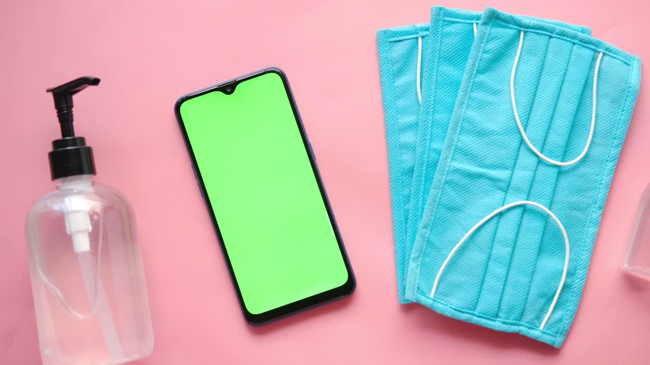 손 소독제, 마스크, 드폰을 분홍색 표면에