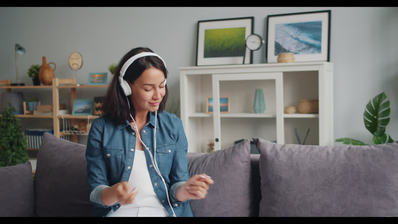 Woman Listening to Music and Dancing on Sofa