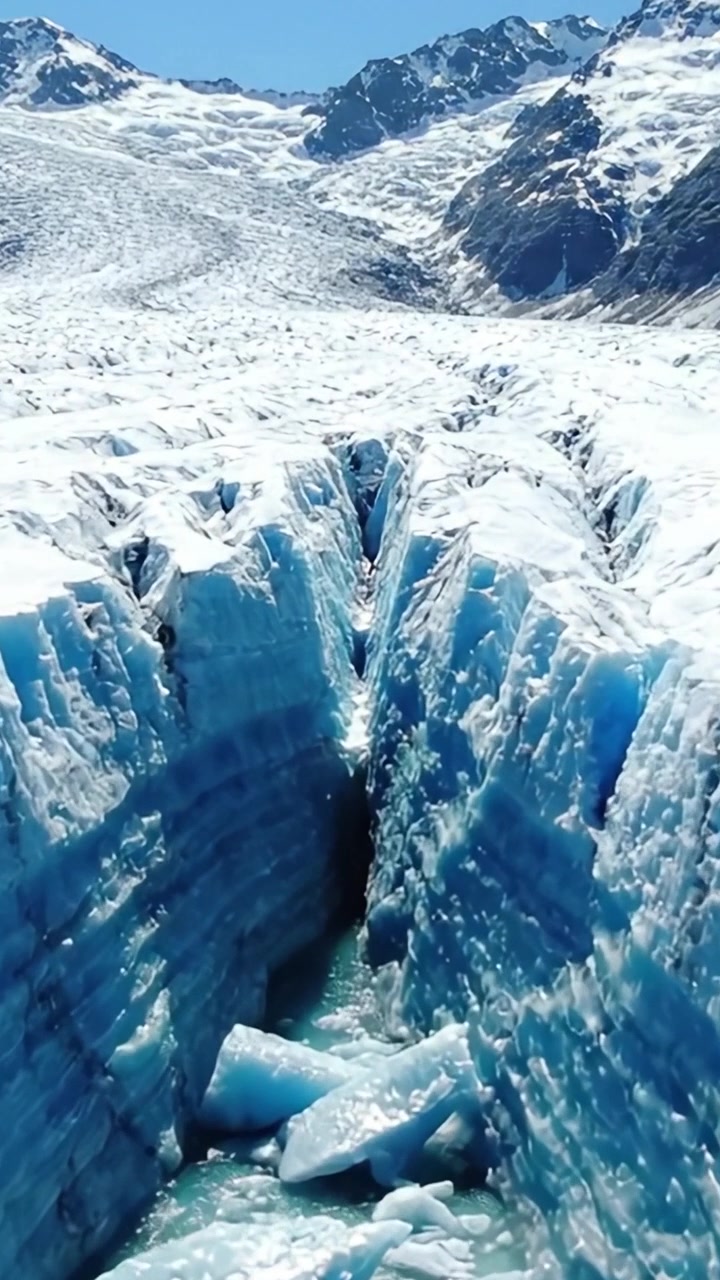 Mozzafiato formazioni di ghiaccio glaciale: un viaggio mozzafiato attraverso le profonde fessure di un maestoso ghiacciaio sotto il cielo azzurro brillante.