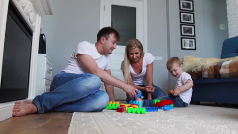 Glückliche-Familie,-Vater,-Mutter-Und-Baby-2-Jahre,-Die-In-Ihrem-Hellen-Wohnzimmer-Lego-Spielen.-Zeitlupenaufnahmen-Einer-Glücklichen-Familie