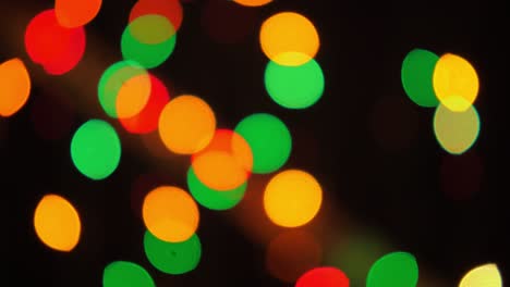bokeh shot of defocused blurred christmas tree light that is blinking on black