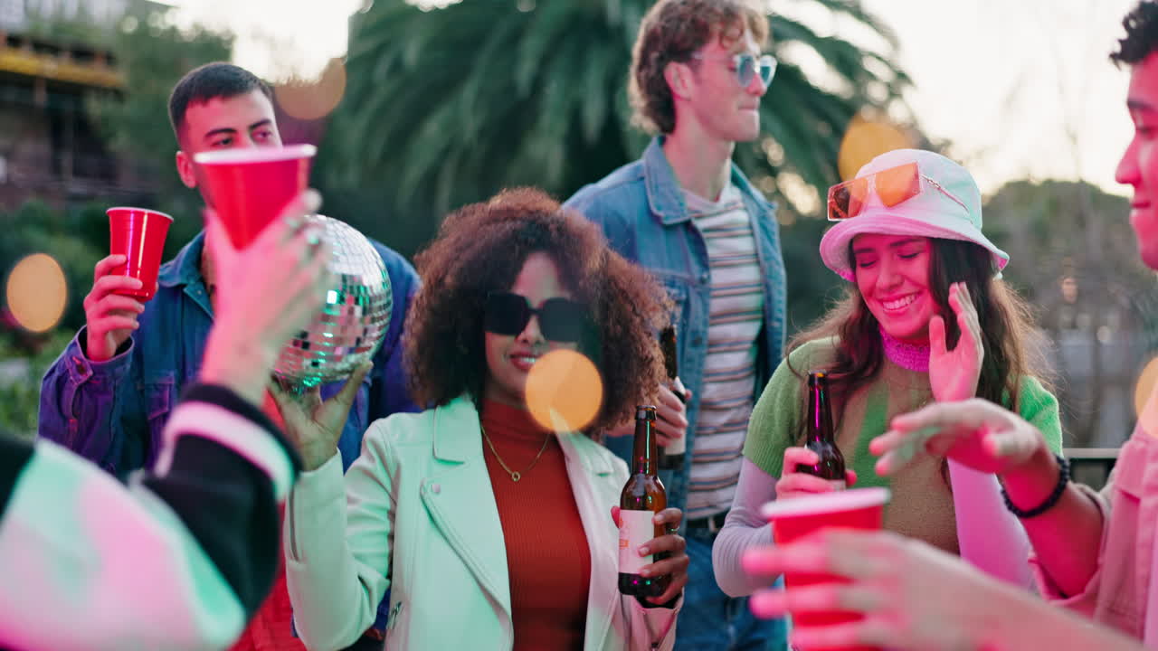 Group of friends having fun at a party with disco ball and red cups