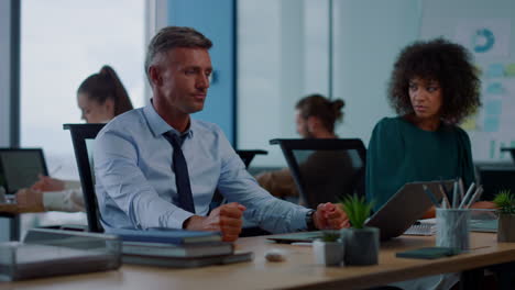 Businessman-sitting-at-office-workplace.-Angry-manager-punching-first-on-table