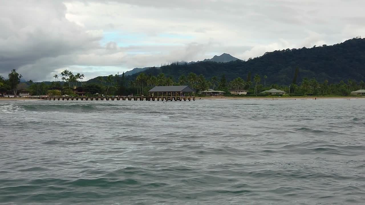 HD 120fps Hawaii Kauai Boating on the ocean floating right to left view of Hanalei Pier and beach with mountain in distance