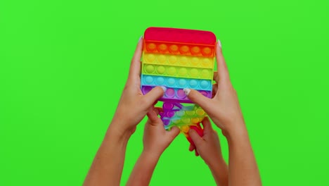 Hands-of-woman-and-kid-play-trendy-push-pop-it-bubble-fidget-anti-stress-toys-game-on-chroma-key