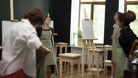 lesson for women in the art workshop, girls putting on aprons