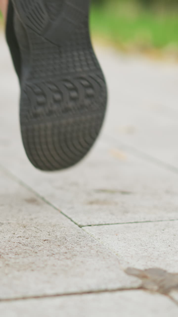 Close-up view of athlete's leg in sneakers on ground, blurred hand in background, preparing to take off for sprint, focus on footwear, athletic readiness, exercise motivation, outdoor training