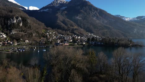 Drone-shot-of-an-isolated-town-located-under-mountain-in-Walensee,-Switzerland