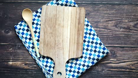 rustic kitchen still life: wooden cutting board and spoon on checkered tablecloth