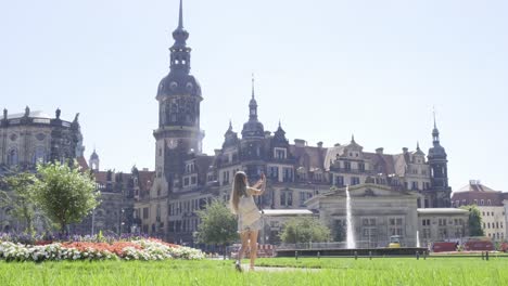 a woman stands in a serene park with a castle in the background a woman stands gracefully on lush grass in a serene park with a historical castle behind her sunlight enhances the tranquil atmosphere