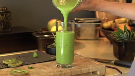 Nahaufnahme-Von-Weiblichen-Händen,-Die-Smoothie-Ins-Glas-Gießen