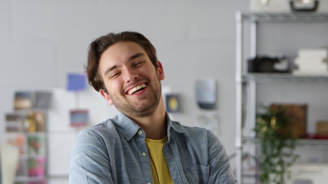 retrato de un estudiante de sexo masculino sonriente o dueño de un negocio que trabaja en la moda por escritorio