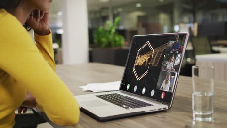 mujer de negocios biracial que usa una computadora portátil para videollamadas con diversos colegas de negocios
