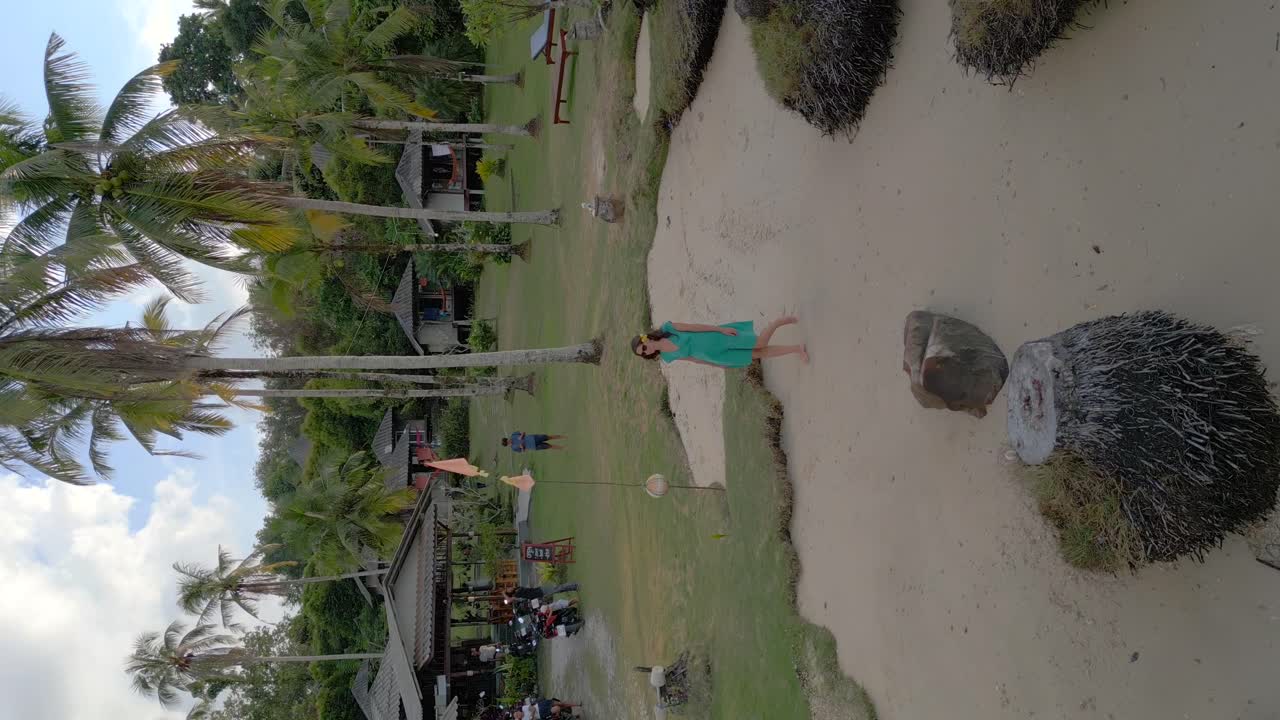 녹색 드레스를 입고 해변을 걷고 있는 여자