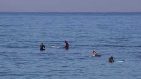 los surfistas a lo largo de la costa de california esperan olas