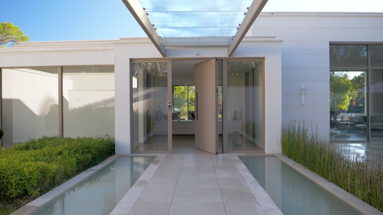 impresionante entrada de porche de cristal de una casa de lujo en cannes con una impresionante puerta que se abre