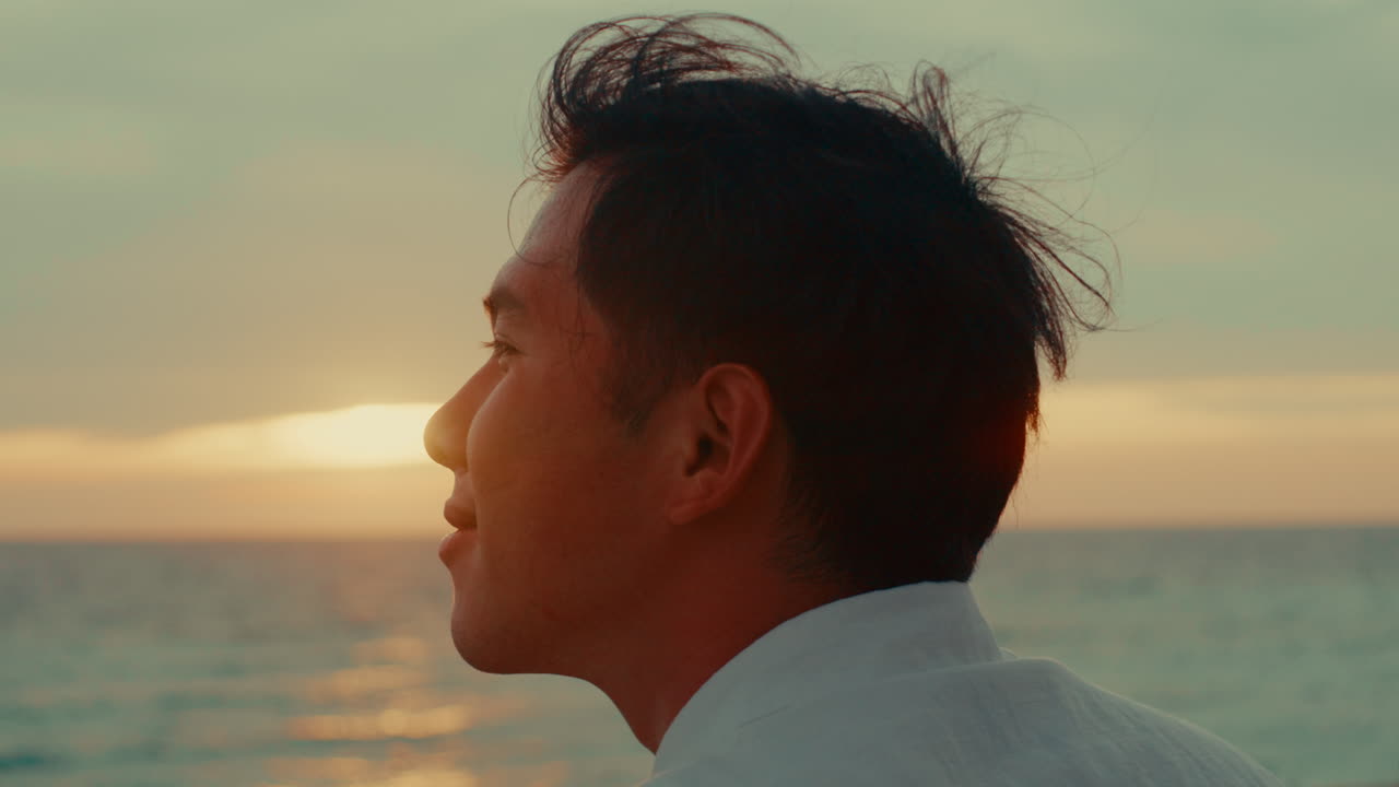 해변에서 해가 지는 것을 보는 남자