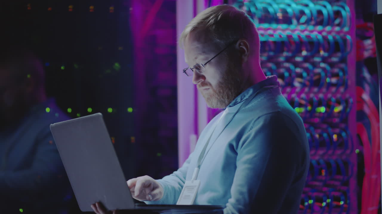 IT Professional Working on Laptop in Data Server Room