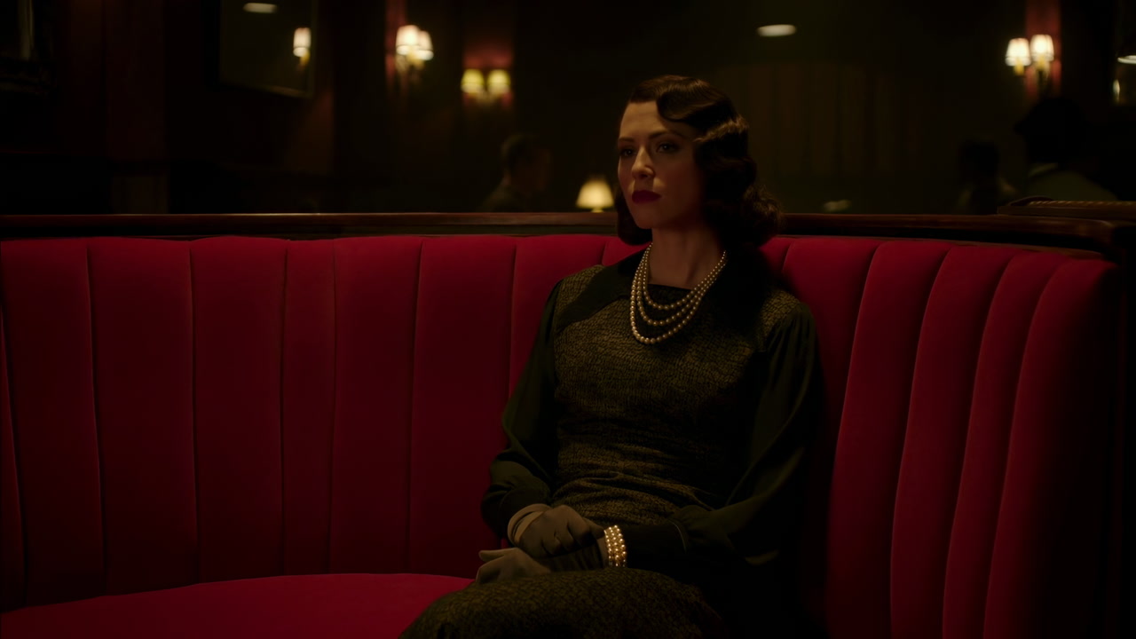 Woman In Red Velvet Booth Quietly Waiting Under Dim Candlelight, S Gown And Pearls, Cinematic Film Noir Mood