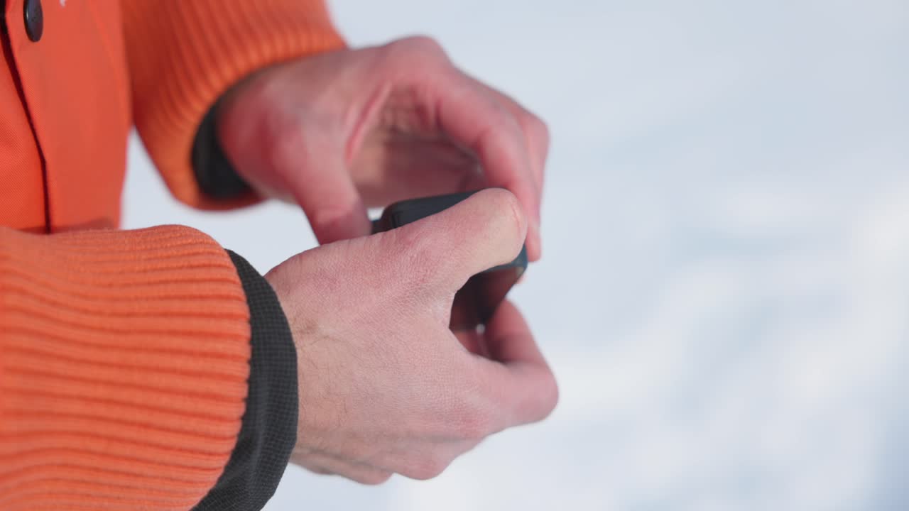 Pulling battery out of Insta360 Ace Pro action camera with snow in background