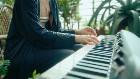 female pianist with gems on hands playing keyboard in orangery