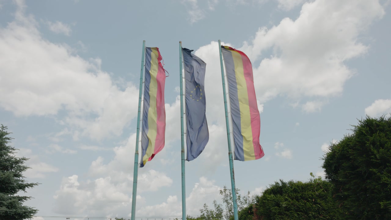 European Union Flag Between The Romanian Flags Waving With The Wind. - static shot