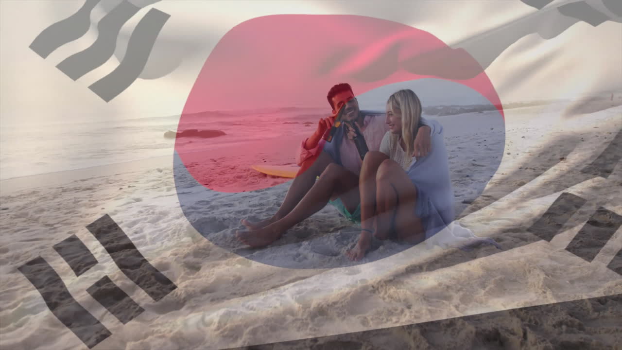 Sitting on beach, couple with South Korean flag animation in foreground