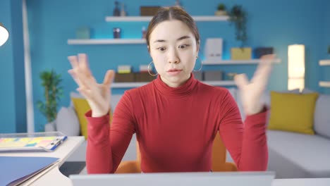 홈 오피스에서 일하는 아시아 여성이 스트레스를 받고 긴장한 상태에서 노트북에서 일하고 있습니다.