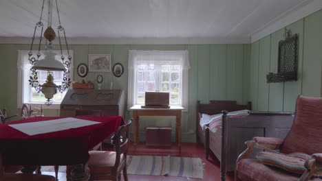 pan shot inside a traditional norwegian wooden hous bedroom, showcasing old-fashioned bed, wooden flooring and furniture