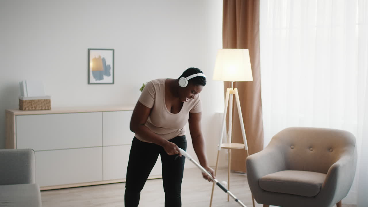 Woman Mopping the Floor While Listening to Music