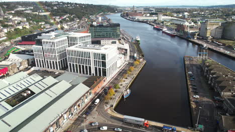 cork city, republic of ireland, drone aerial view of bridge traffic on river lee and buildings on riverbanks on sunny autumn day