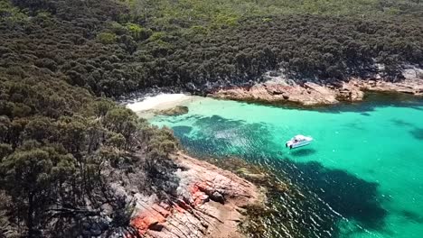 barco anclado en una pequeña cala secreta filmado con un avión no tripulado, playa de peligro wineglass bay tasmania