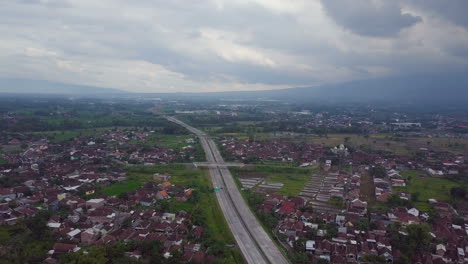 vuelo aéreo de drones sobre la carretera nocturna y las casas en el pueblo de java en indonesia