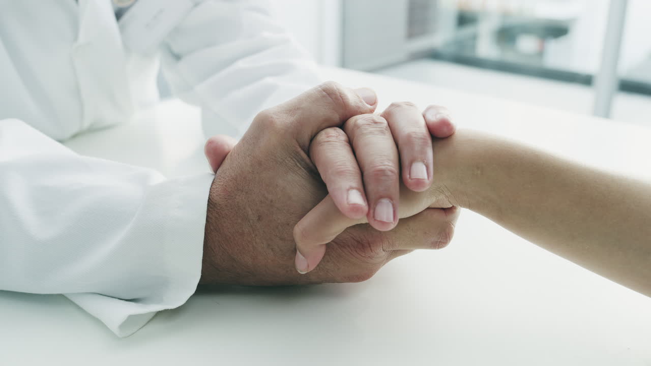 el médico sosteniendo la mano del paciente