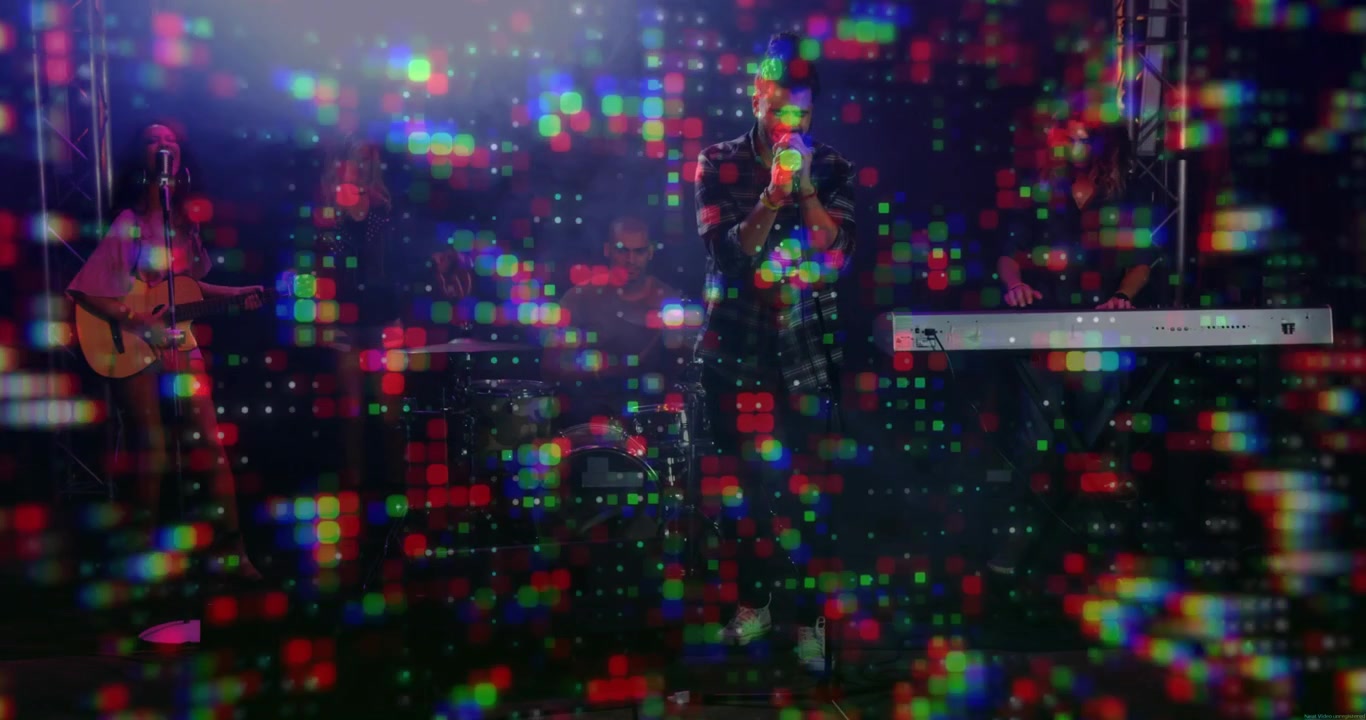 Pixel projection starting, lead singer singing into handheld microphone while band performing song