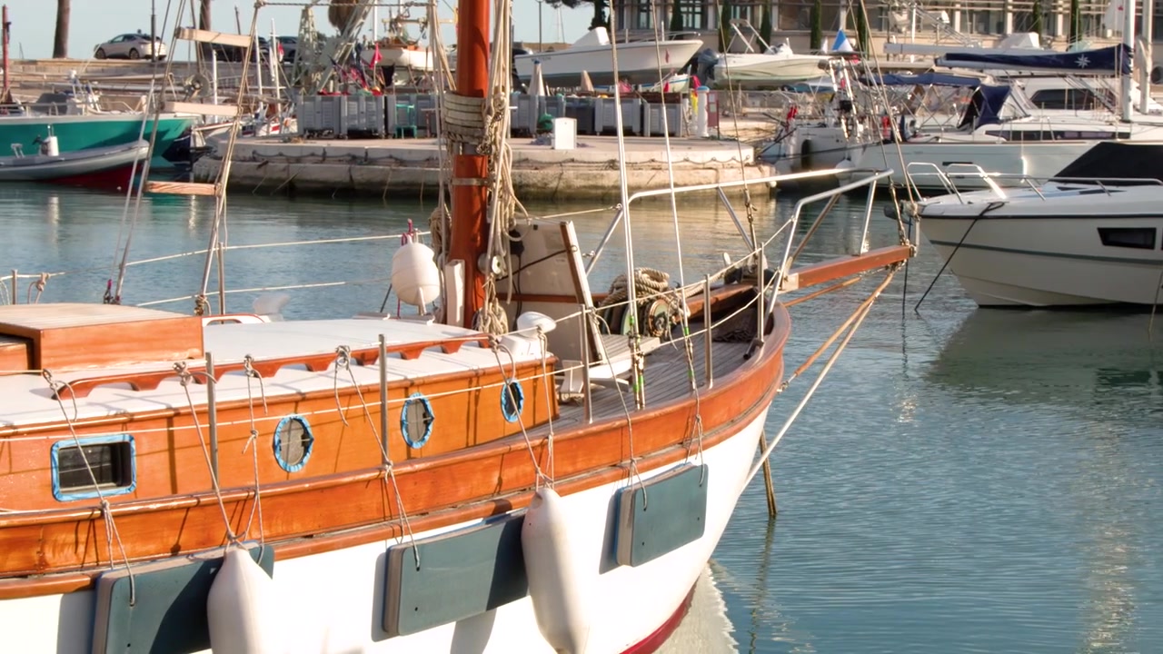 Ampia inquadratura statica di uno yacht in legno d'epoca ormeggiato in un tranquillo porto francese