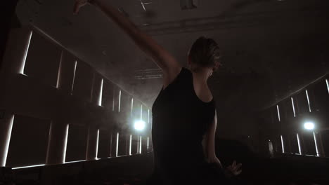 SLOW-MOTION:-Ballerina-dancing-in-Pointe-shoes-on-stage-in-smoke-in-the-dark-light-back-view.-the-camera-moves-on-gimbal