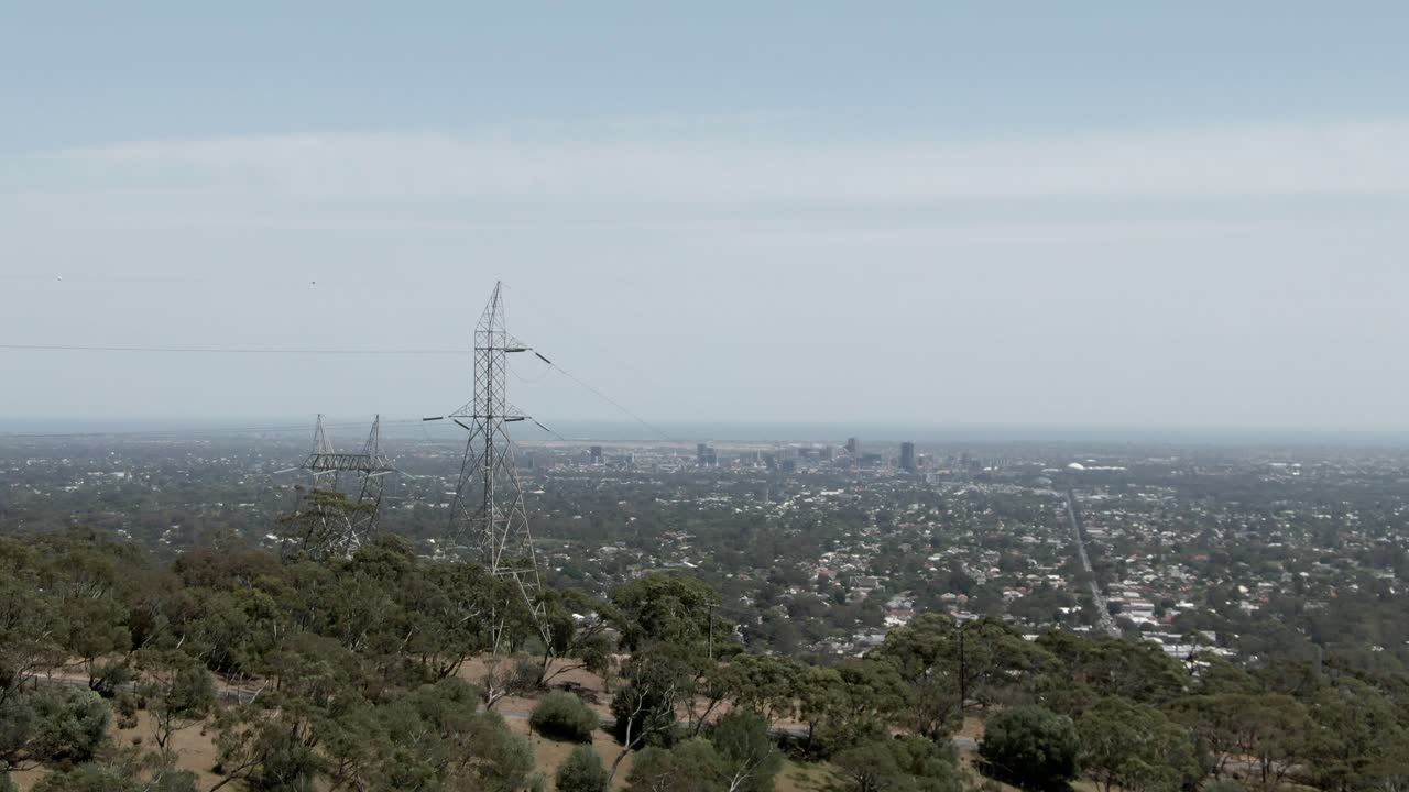 Electricity Pylons On Mountain With Overview Of Adelaide City In Australia On A Sunny Day