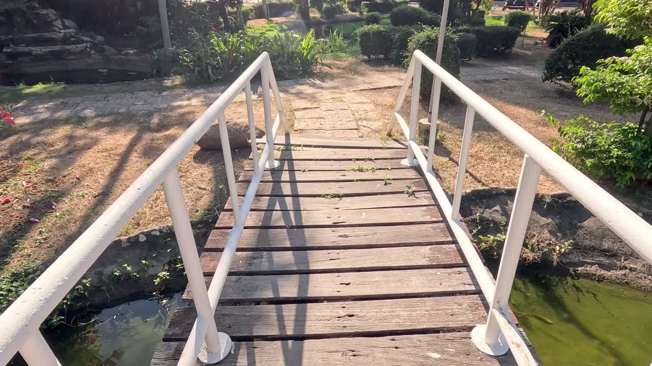 물 위 의 나무 다리 를 가로질러 진행