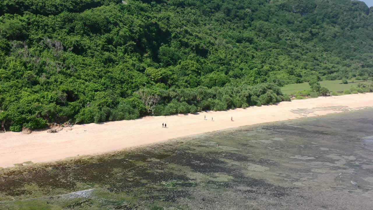 turistas en la playa vacía de arena blanca en uluwatu bali en un día soleado, aéreo