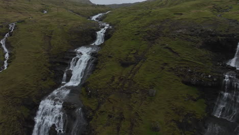 Oyggjarvegur-mountain,-Faroe-Islands:-close-aerial-view-traveling-in-to-the-waterfalls-of-this-great-mountain,-near-the-Kaldbaksfjørður-fjord