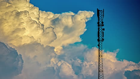 una nube de cúmulo se forma en un cielo azul junto a una torre de teléfono celular