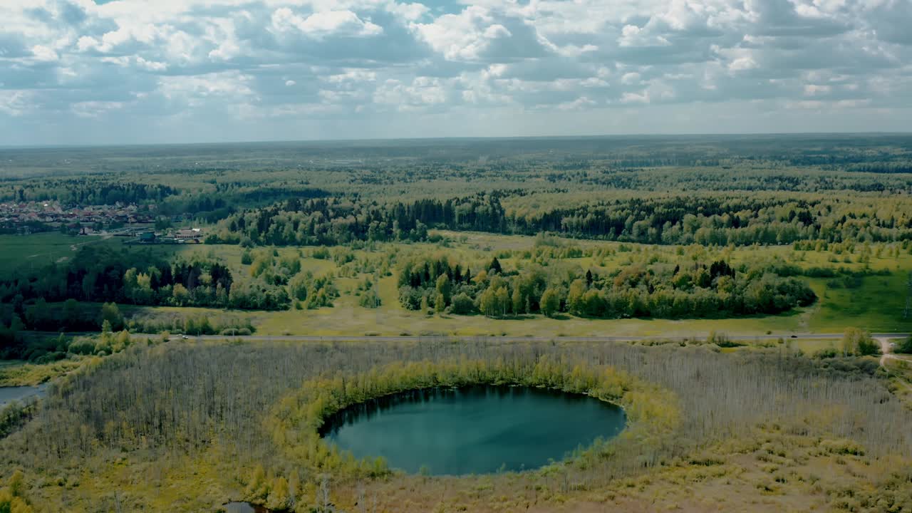 дрон летит над вершинами, приближается к березам и озеру в москве.