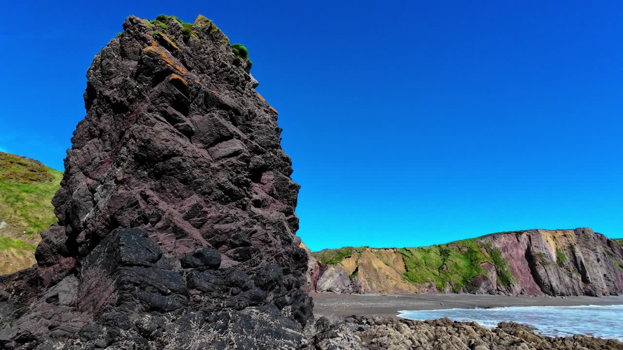 seastack acantilados y playa con cielo azul y olas ballydwane playa costa de cobre waterford irlanda