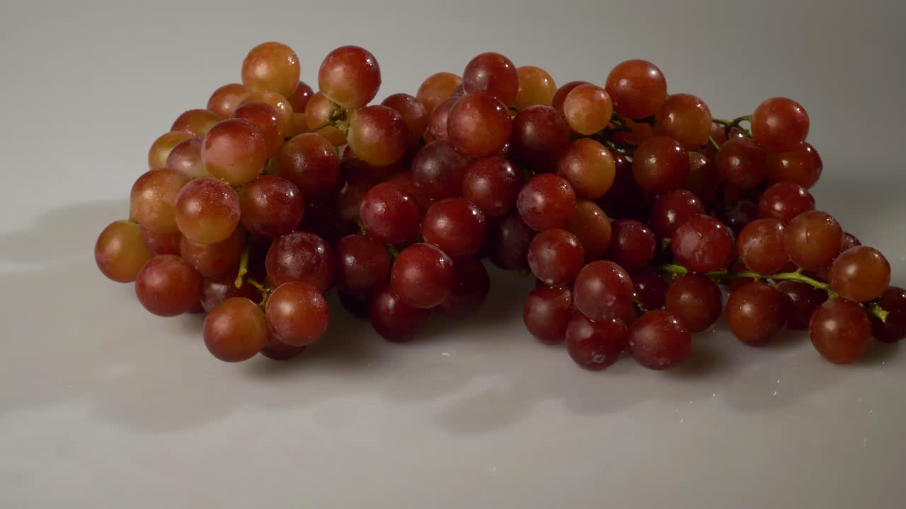 uvas rojas sin semillas sobre una superficie blanca