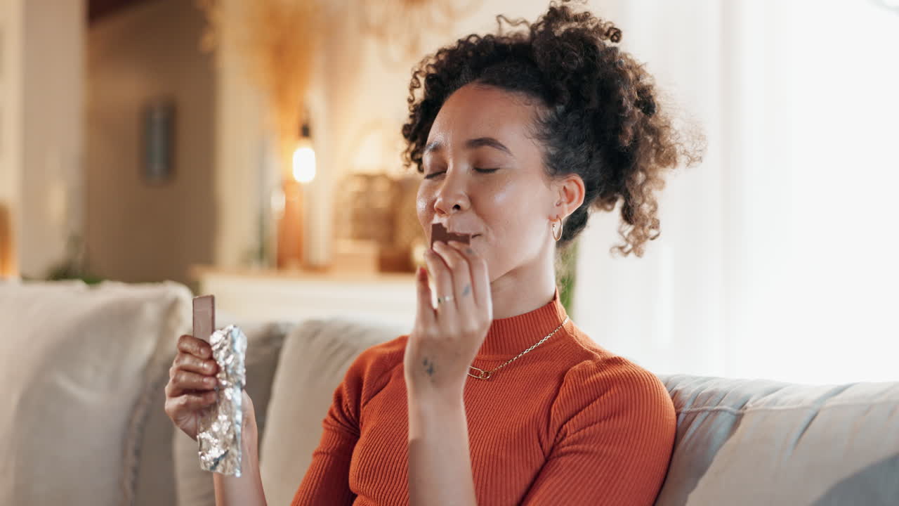 mujer disfrutando de una barra de chocolate en casa