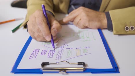 la mano de un hombre de negocios trabajando en datos estadísticos.