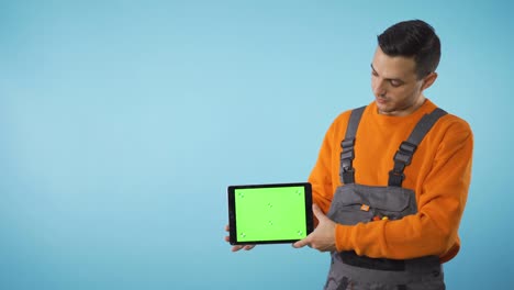 tableta de pantalla verde en la mano del hombre con espacio de copia aislado en fondo azul
