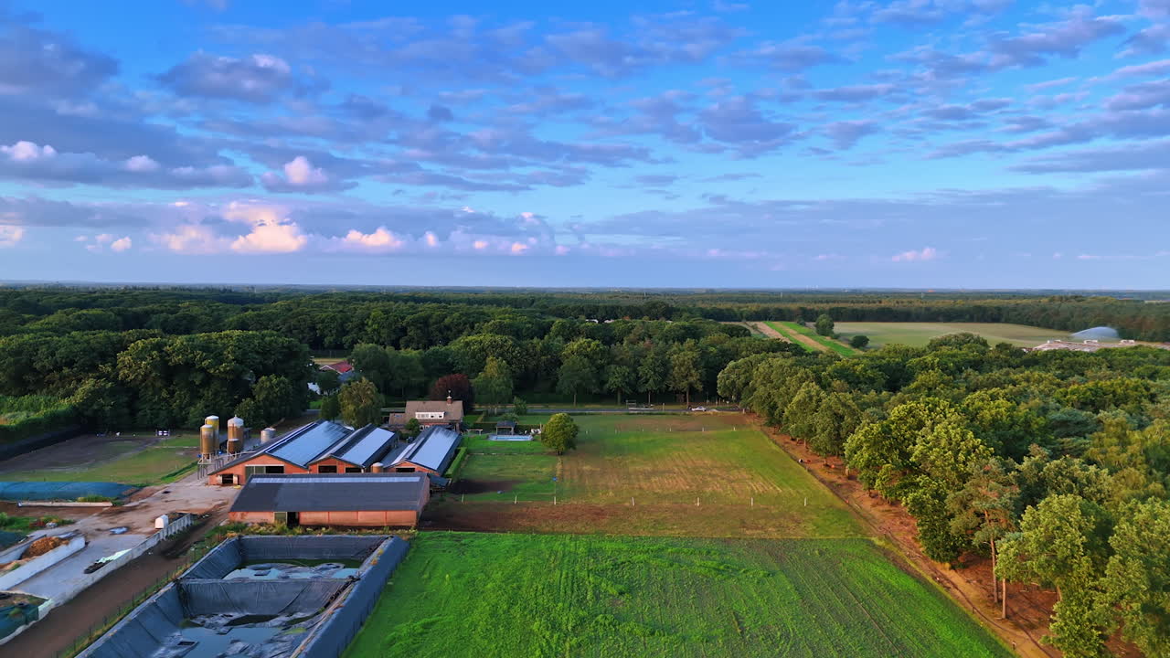 Scenic aerial view of a rural landscape. A vibrant aerial view showcases a peaceful rural area with fields, a farm, and lush greenery under a blue sky