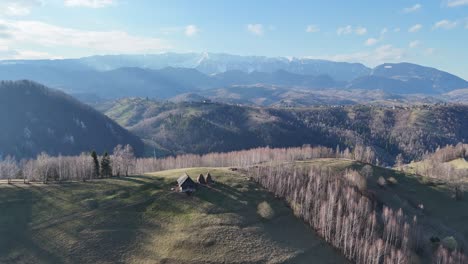 Beautiful-mountain-landscape-with-rolling-hills-and-sparse-trees-under-a-blue-sky